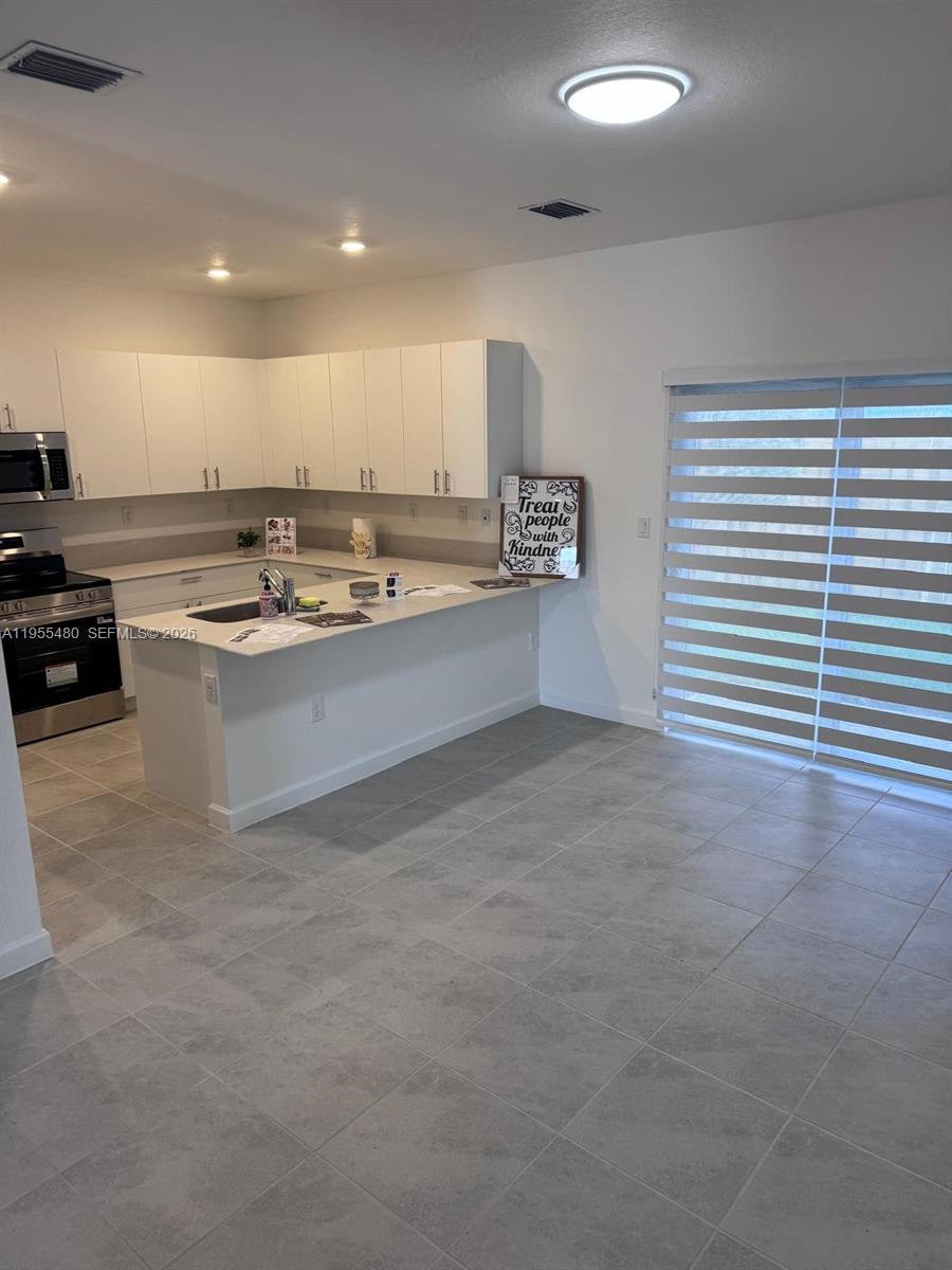 2721 Southeast 26th Road, Unit 2721 Homestead, FL 33035 - Photo 12 of 55 a kitchen with stainless steel appliances a sink stove and cabinets