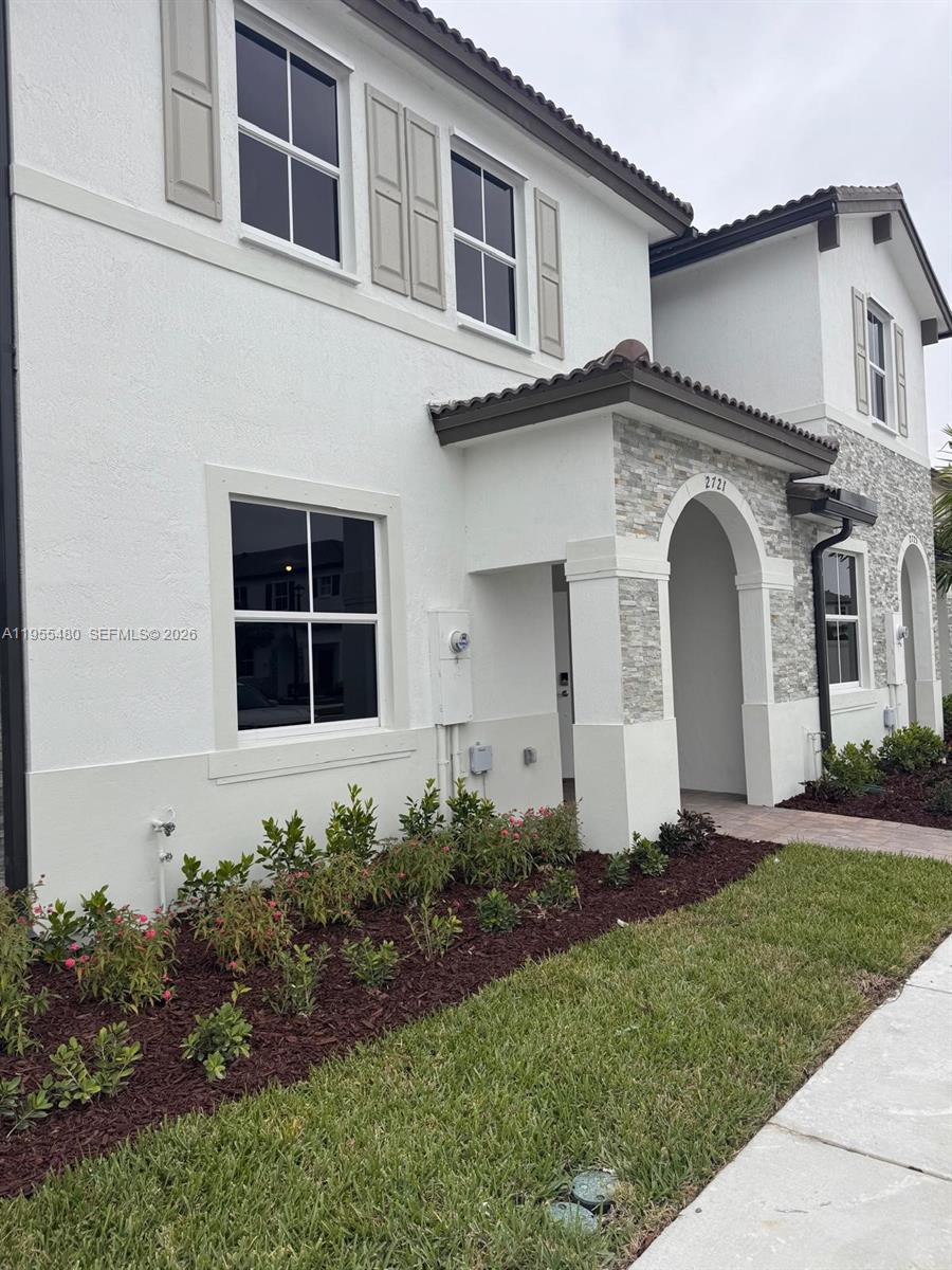 2721 Southeast 26th Road, Unit 2721 Homestead, FL 33035 - Photo 2 of 55 a front view of a house with a garden