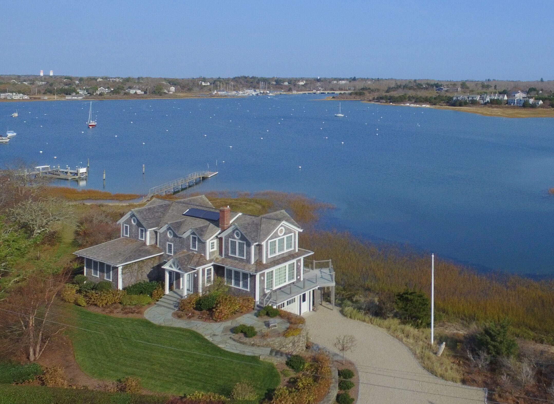 an aerial view of residential houses with outdoor space and ocean view