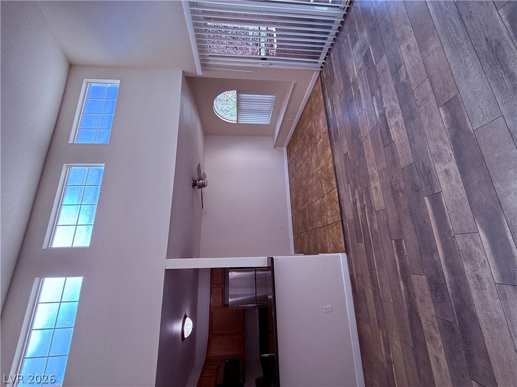 Sun-filled living area with vaulted ceilings and rich wood-style flooring.