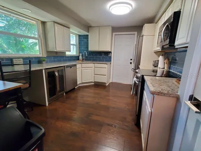 a kitchen with stainless steel appliances a refrigerator sink and cabinets