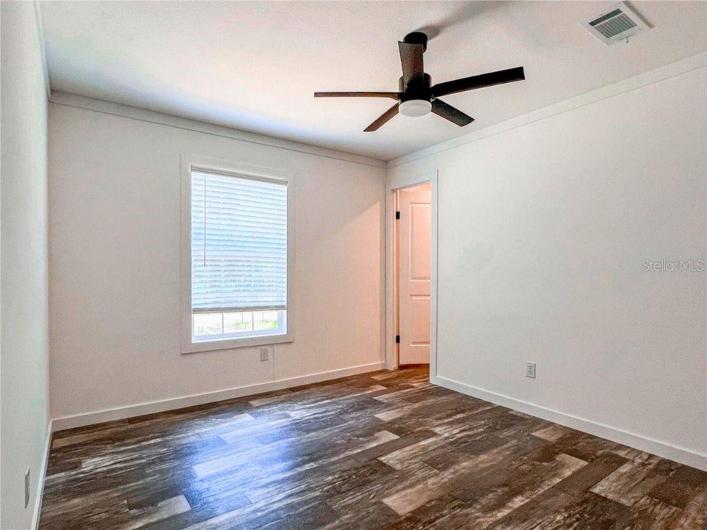 16108 Gupton Street Brooksville, FL 34613 - Photo 23 of 27 a view of a livingroom with a hardwood floor and a ceiling fan