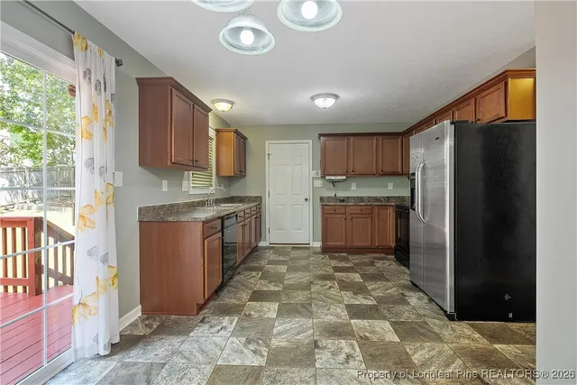 a kitchen with stainless steel appliances granite countertop a stove top oven a refrigerator and a sink with granite countertops