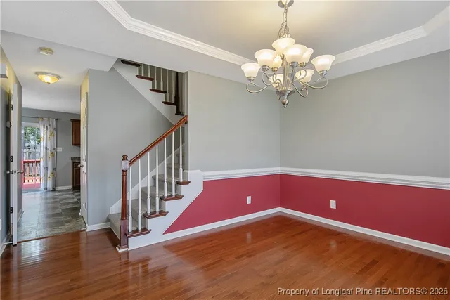 a yellow room with wooden floor and chandelier