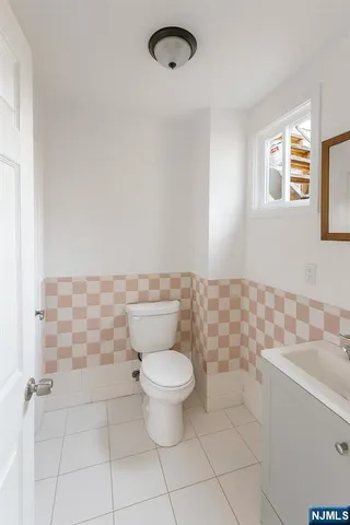 a bathroom with a toilet a sink and a mirror