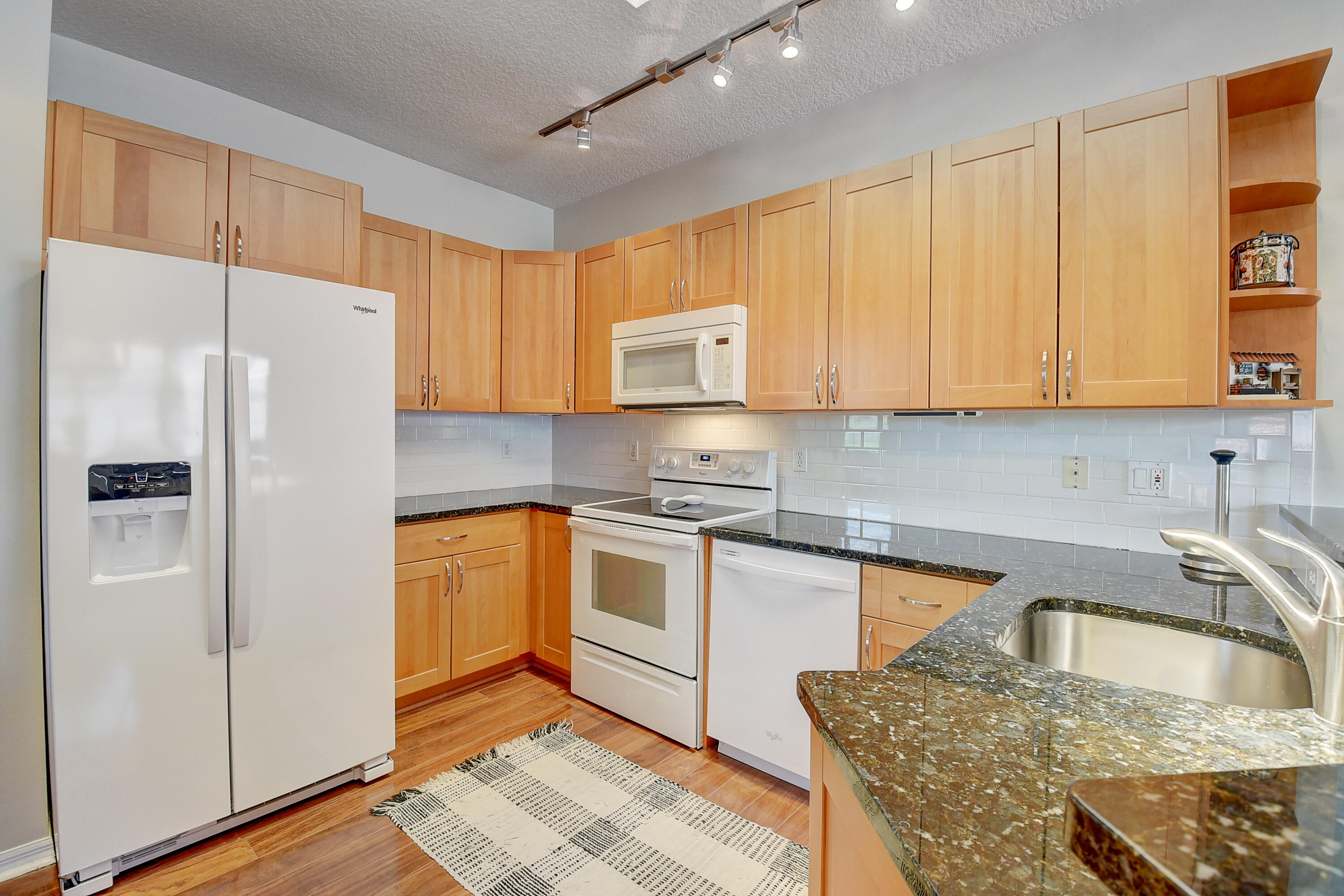 8652 Vía Reale, Unit 2 Boca Raton, FL 33496 - Photo 14 of 58 a kitchen with stainless steel appliances granite countertop a refrigerator sink and cabinets