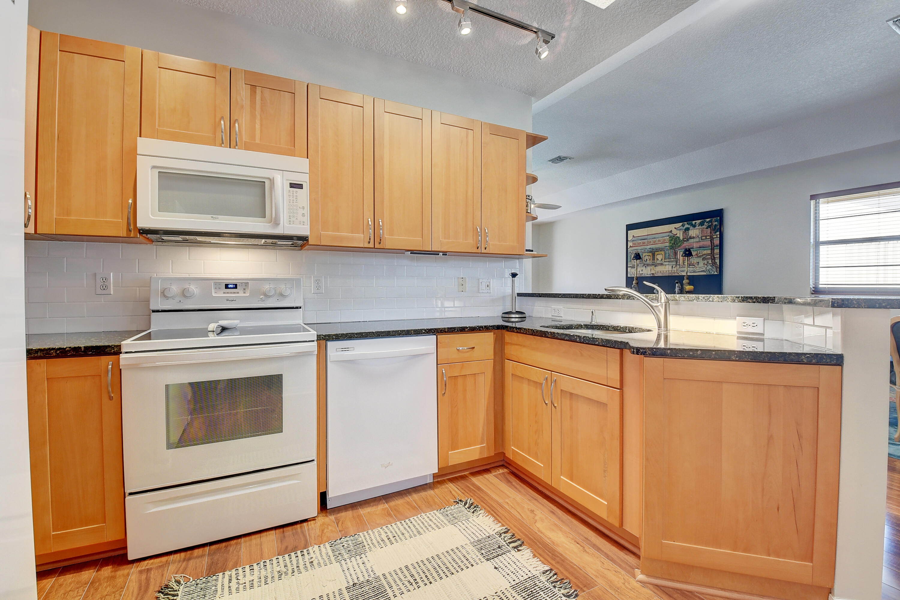 8652 Vía Reale, Unit 2 Boca Raton, FL 33496 - Photo 15 of 58 a kitchen with granite countertop cabinets stainless steel appliances and a sink