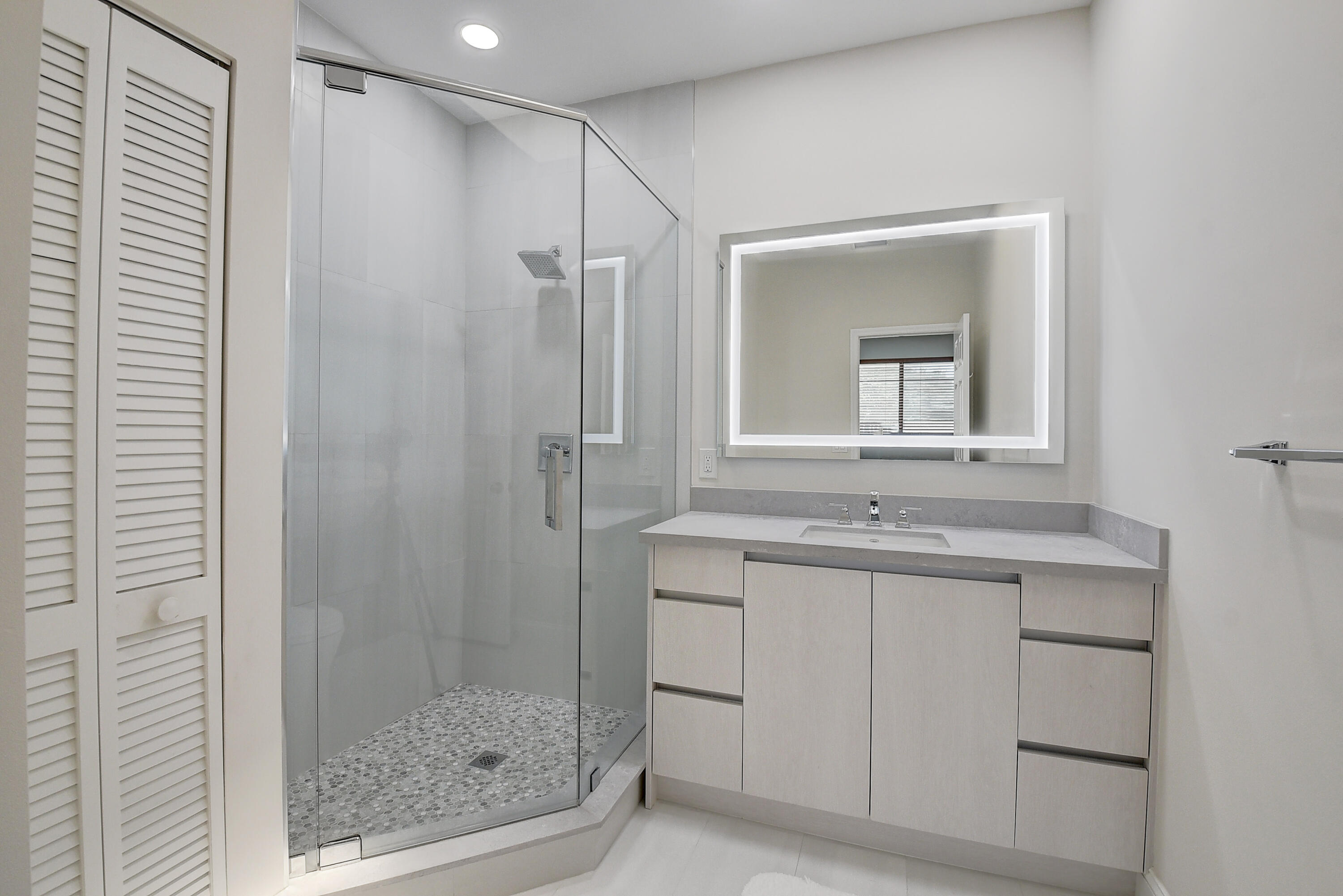 8652 Vía Reale, Unit 2 Boca Raton, FL 33496 - Photo 22 of 58 a bathroom with a shower sink and mirror