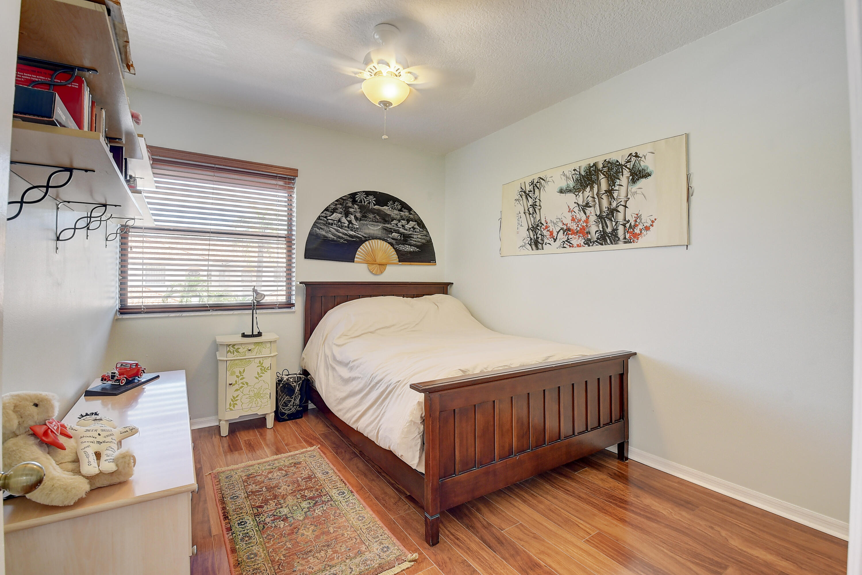 8652 Vía Reale, Unit 2 Boca Raton, FL 33496 - Photo 25 of 58 a bedroom with a bed and a chandelier