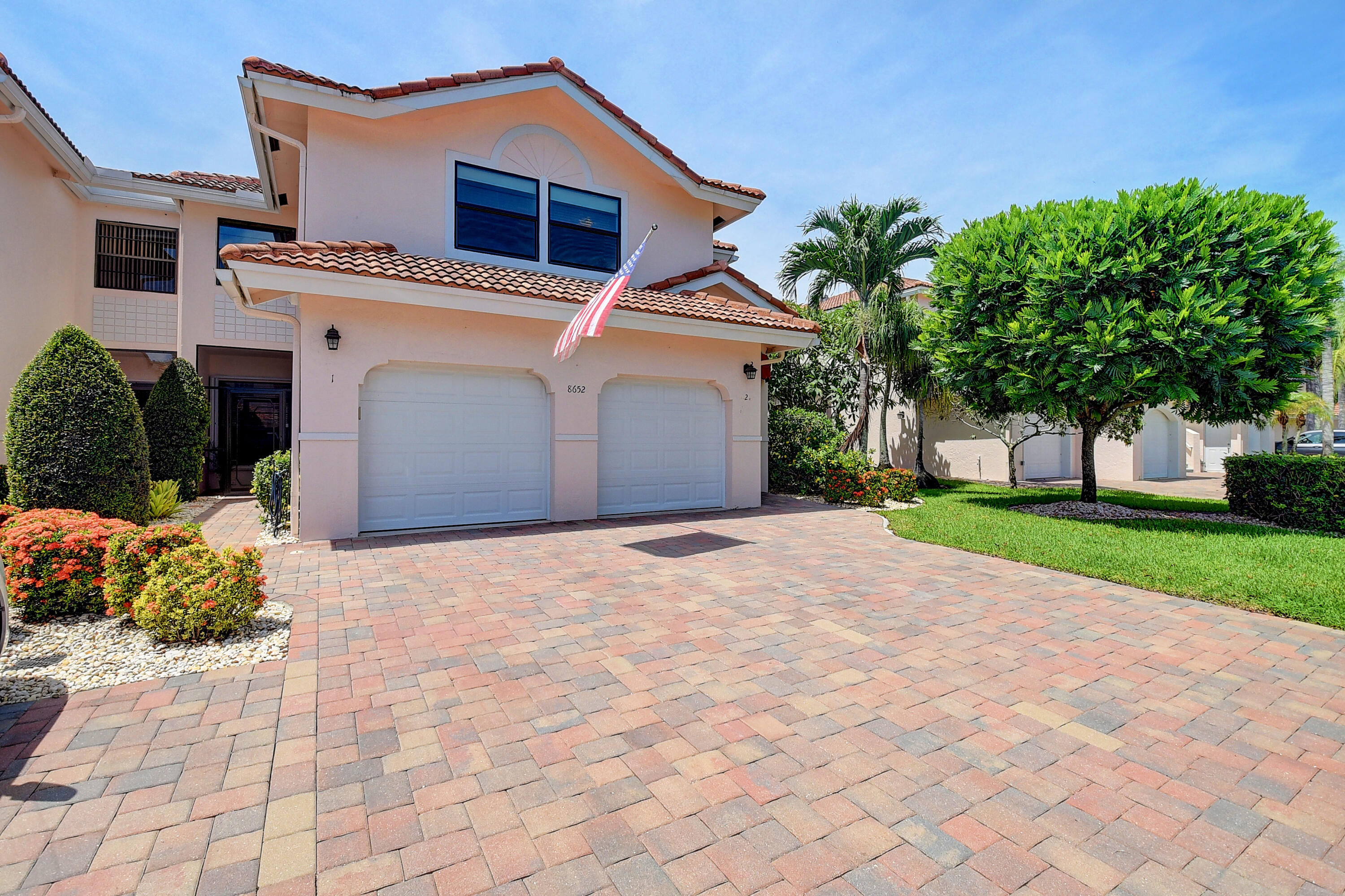 8652 Vía Reale, Unit 2 Boca Raton, FL 33496 - Photo 3 of 58 a front view of a house with a yard and a garage