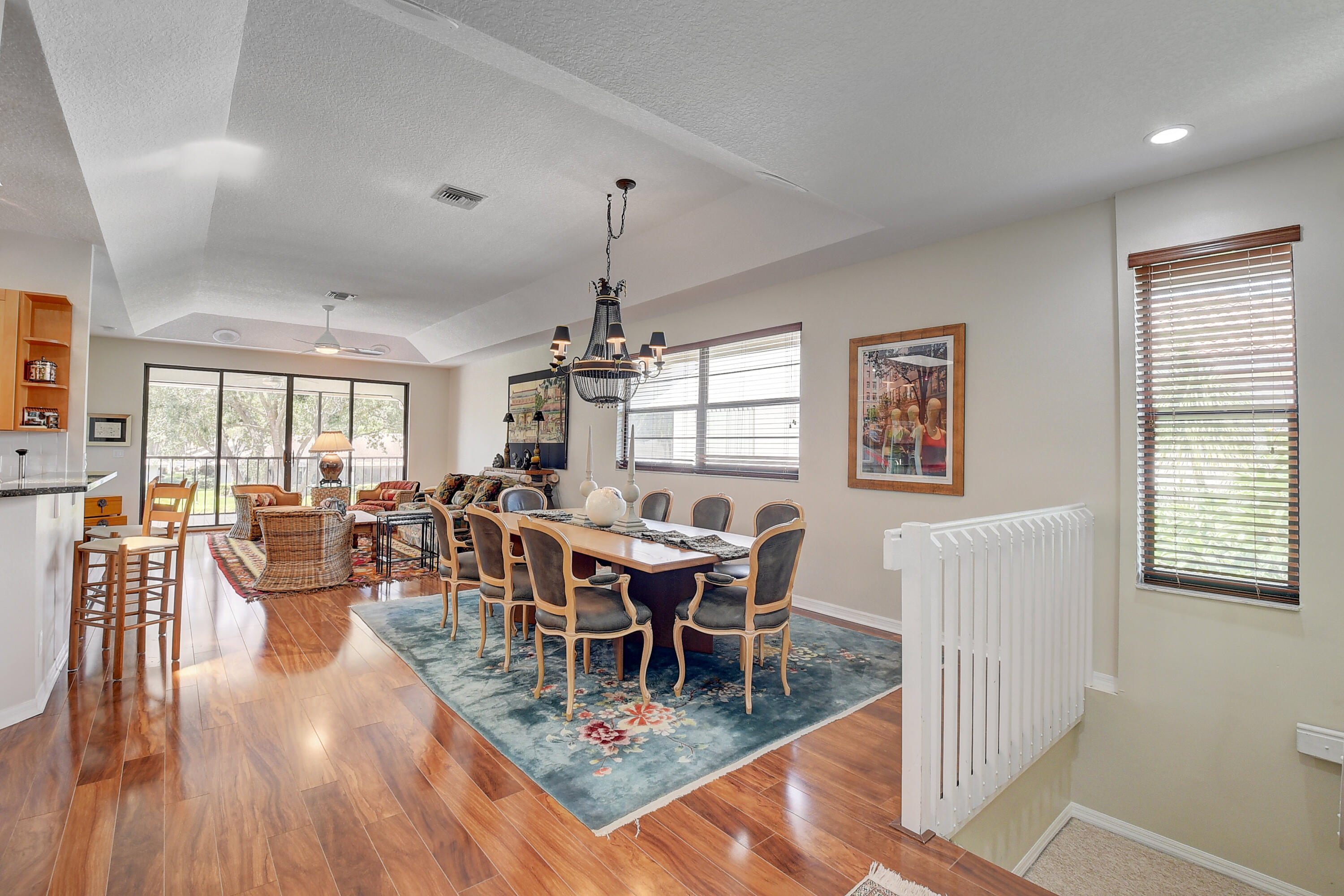 8652 Vía Reale, Unit 2 Boca Raton, FL 33496 - Photo 6 of 58 a dining room with wooden floor a chandelier a wooden table and chairs