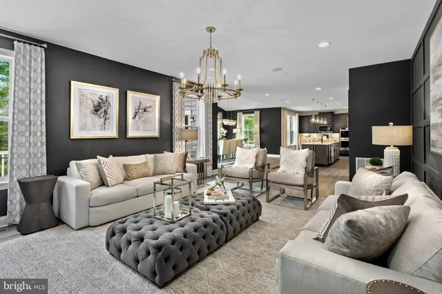 a living room with furniture ceiling fan and a chandelier