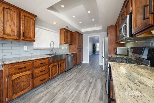 1221 Andrea Court Ridgecrest, CA 93555 - Photo 16 of 50 a large kitchen with stainless steel appliances granite countertop a lot of counter space and wooden floors