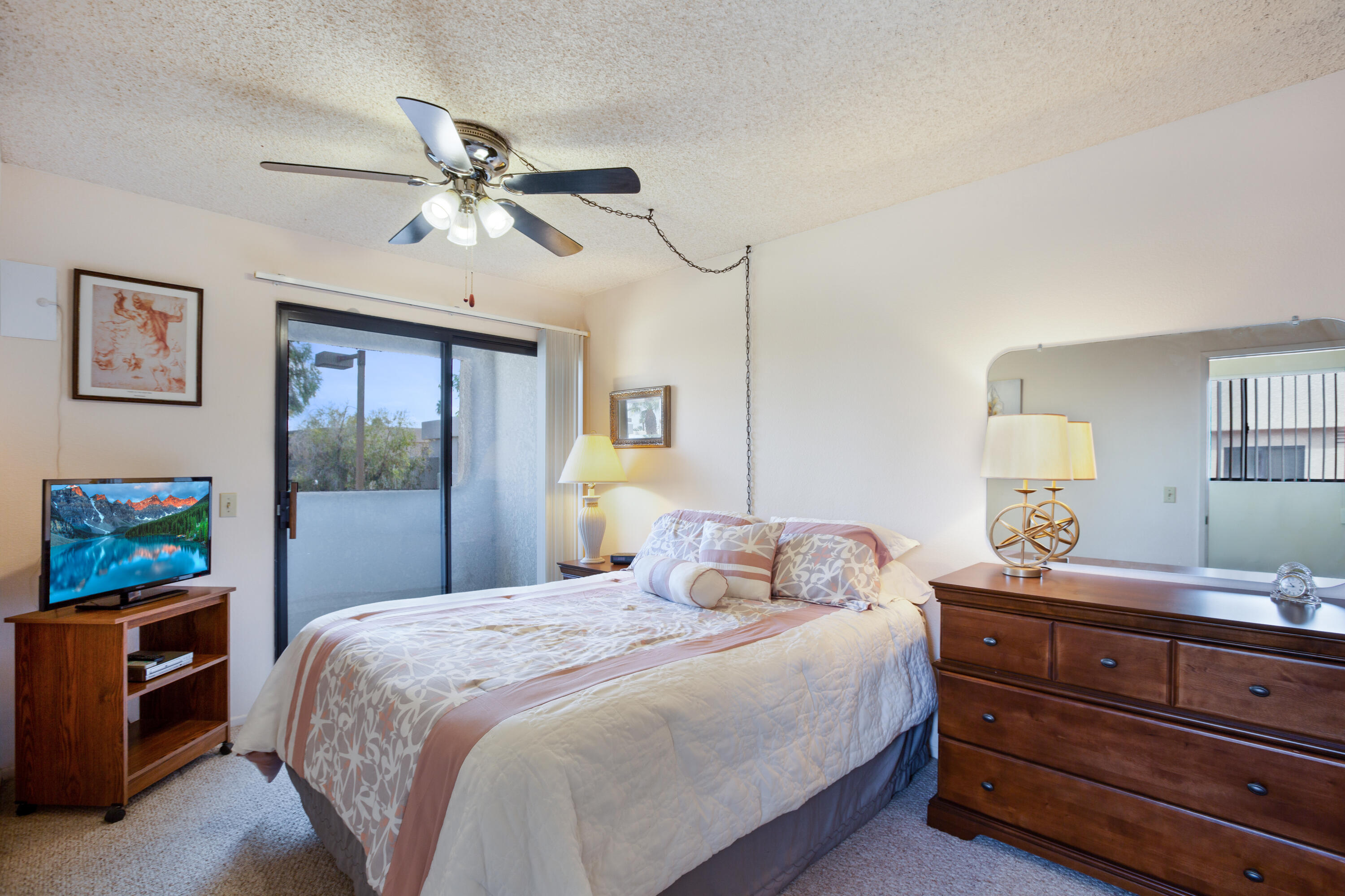 34352 Laura Way Rancho Mirage, CA 92270 - Photo 19 of 36 a bedroom with a bed and a chandelier