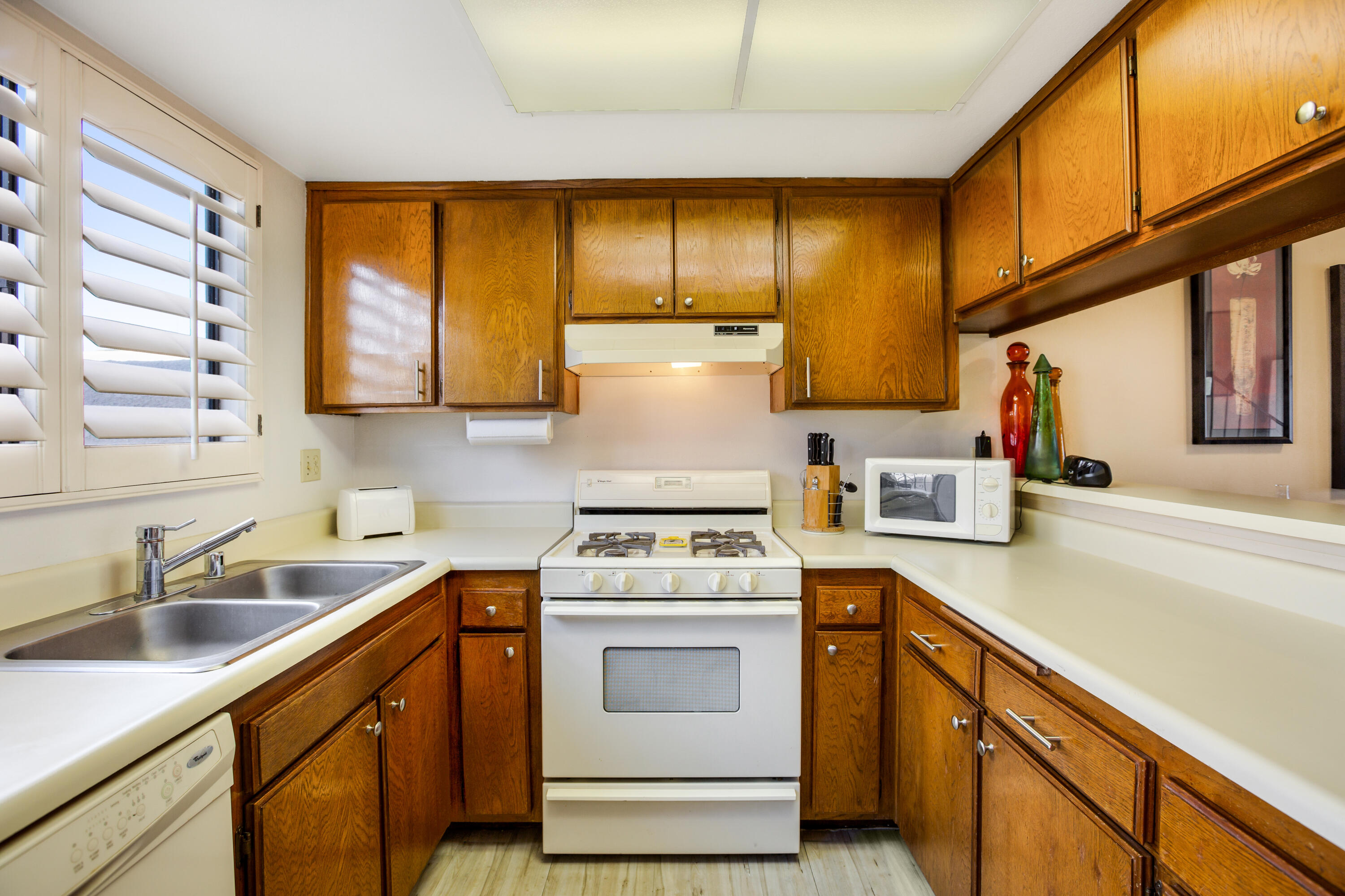 34352 Laura Way Rancho Mirage, CA 92270 - Photo 8 of 36 a kitchen with a sink a stove cabinets and a wooden floor