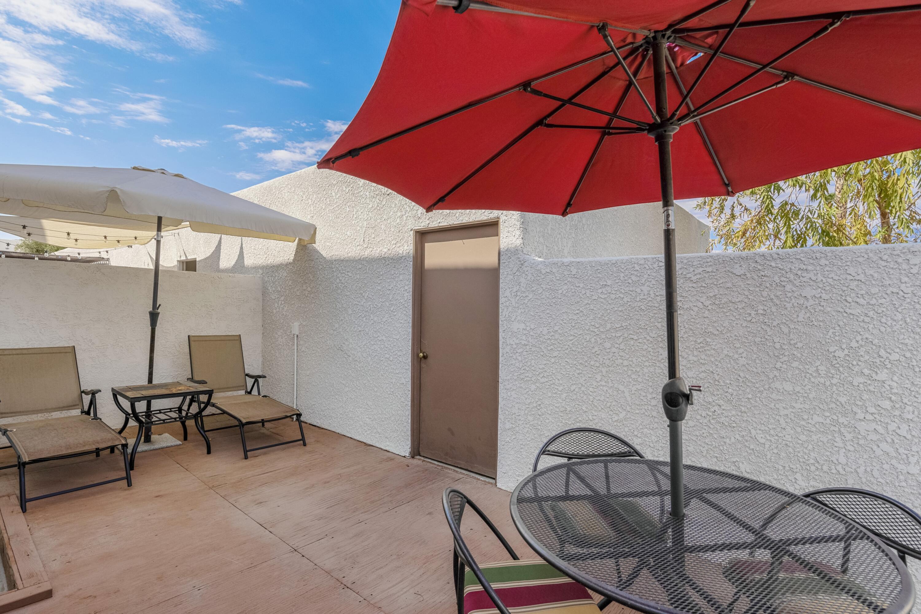 34352 Laura Way Rancho Mirage, CA 92270 - Photo 10 of 36 a patio with a table and chairs under an umbrella