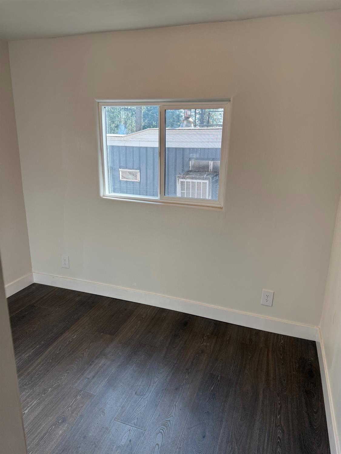 6060 Pony Express Trail, Unit 18 Pollock Pines, CA 95726 - Photo 16 of 17 a view of an empty room with wooden floor and a window