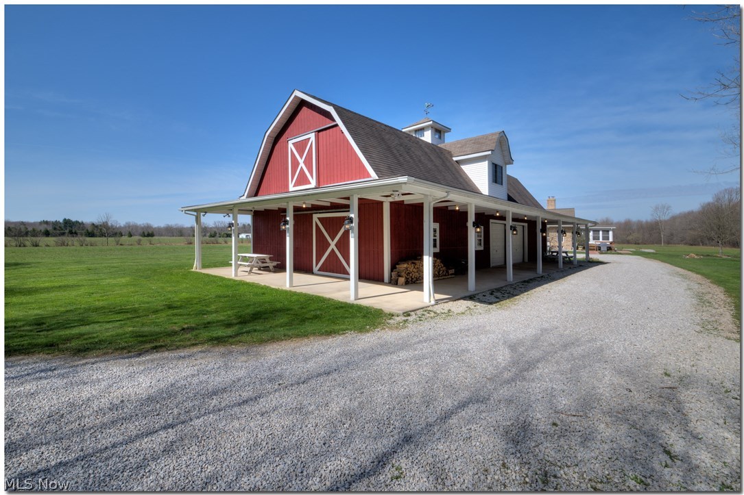 17580 Huntley Road Windsor, OH 44099 - Photo 25 of 35 Large overhang with lights under overhang and on posts, concrete pad. Barn doors above and below for moving items in and out. Windows are vinyl double paned. The barn has water and gas