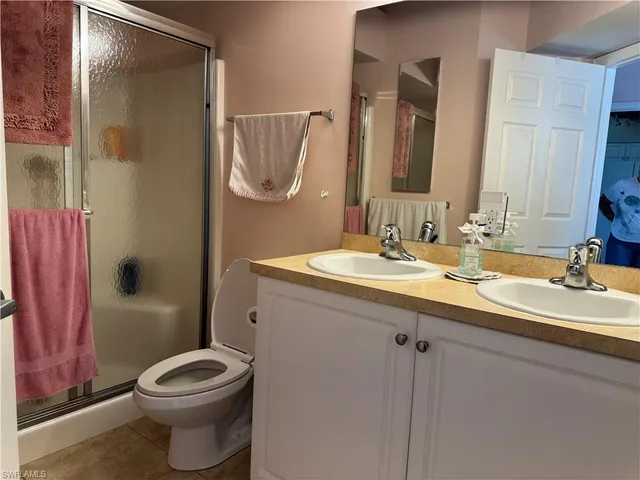 a bathroom with a double vanity sink toilet and shower