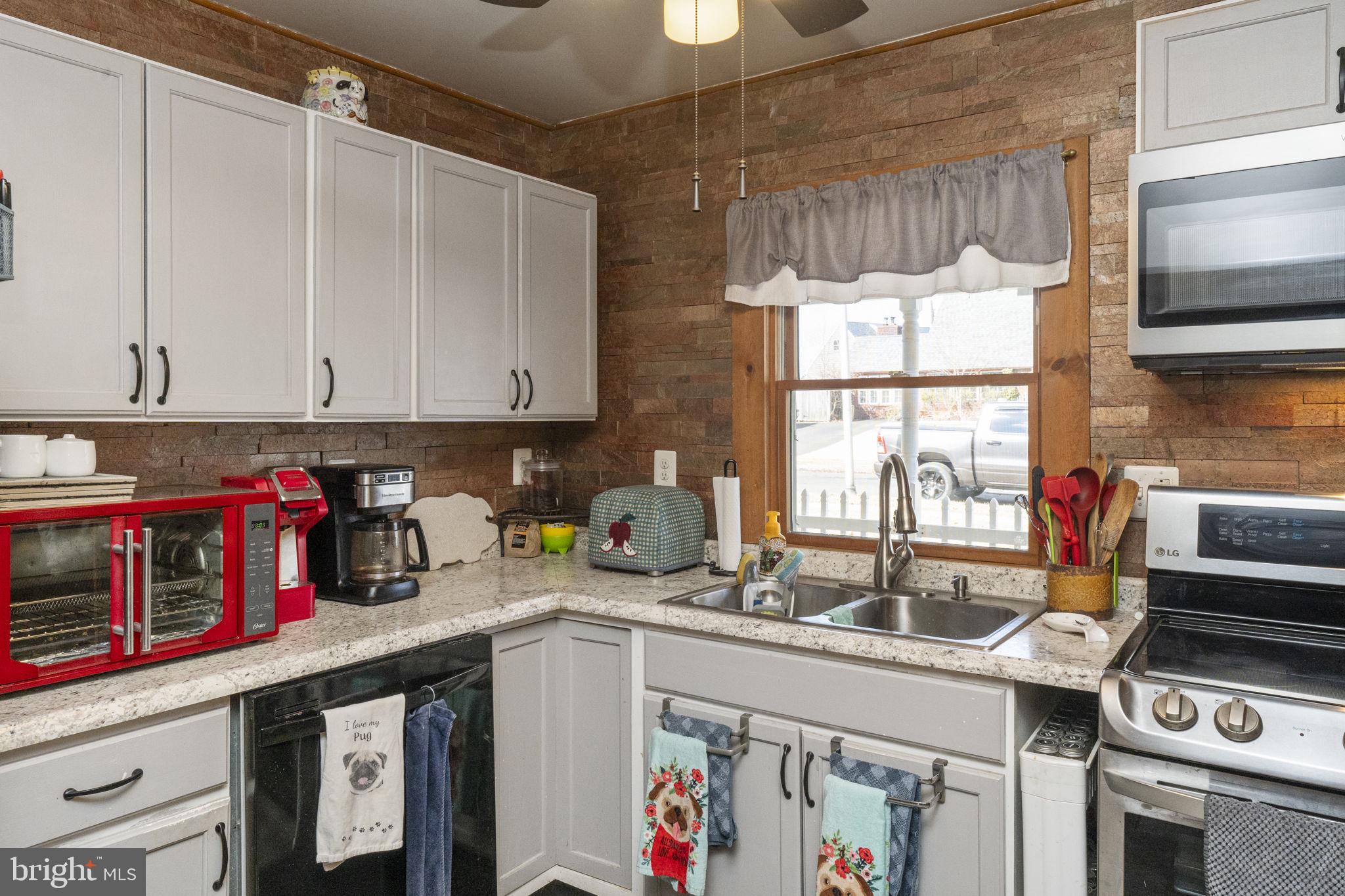 60 Inland Road Levittown, PA 19057 - Photo 11 of 32 a kitchen with stainless steel appliances granite countertop a stove a sink and a microwave