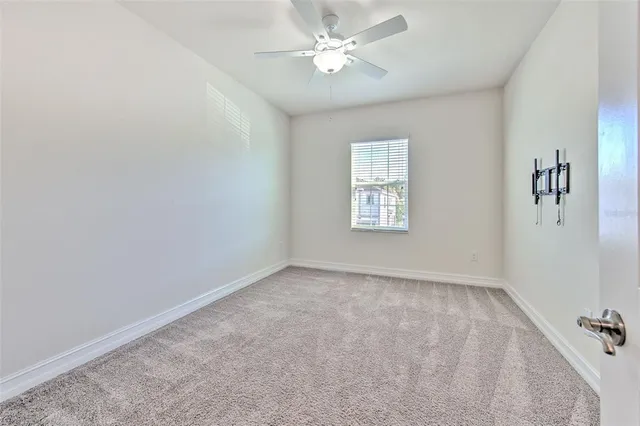 an empty room with windows and fan