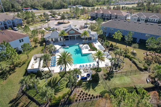 an aerial view of residential houses with outdoor space and swimming pool