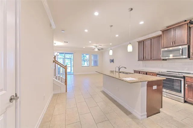 a large kitchen with stainless steel appliances granite countertop a sink and cabinets