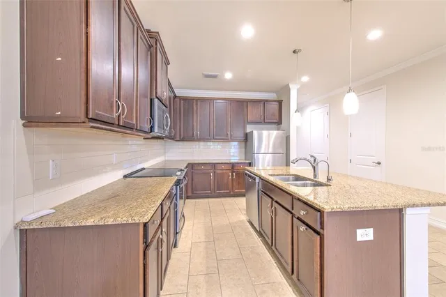 a kitchen with stainless steel appliances granite countertop a sink stove and cabinets