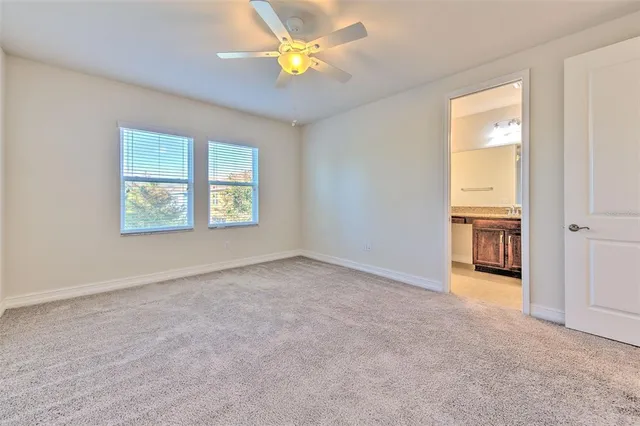 an empty room with a window and a ceiling fan
