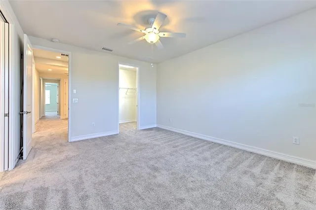 an empty room with a ceiling fan and a window