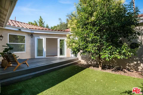 a view of house with backyard outdoor seating and hardwood