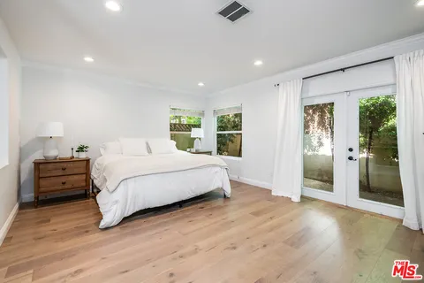 a spacious bedroom with a large bed and a dresser
