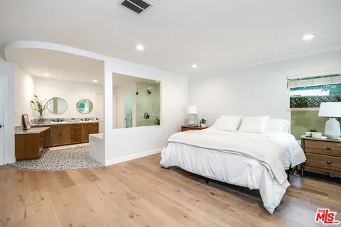 a bedroom with a large bed and a view of living room