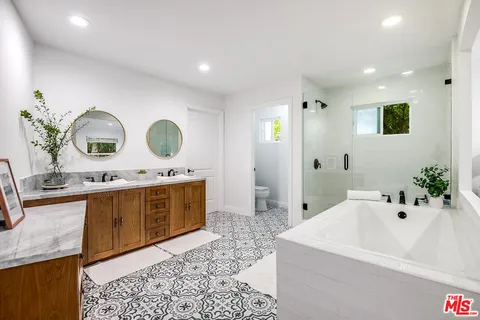 a spacious bathroom with a tub sink and mirror