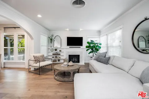 a living room with furniture a fireplace and a large window