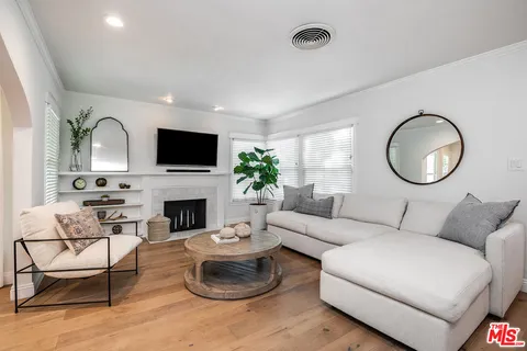 a living room with furniture a fireplace and a large mirror