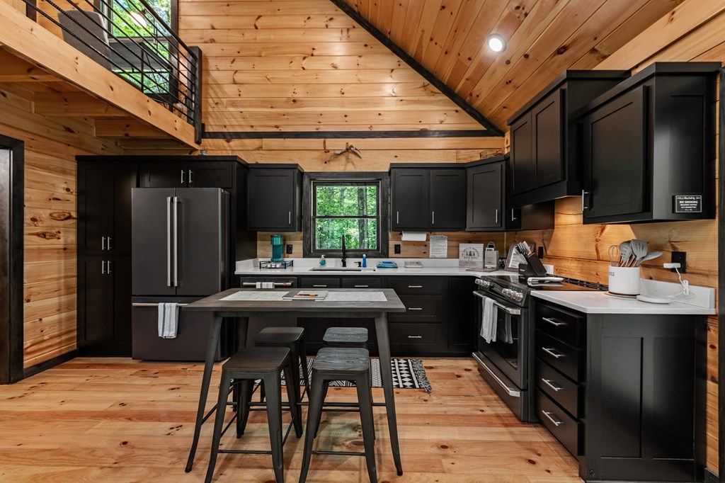 25 Hidden Ridge Cherry Log, GA 30522 - Photo 30 of 52 a kitchen with stainless steel appliances kitchen island granite countertop a table chairs in it and wooden floors