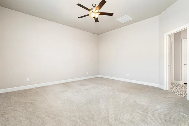 an empty room with a window and a ceiling fan
