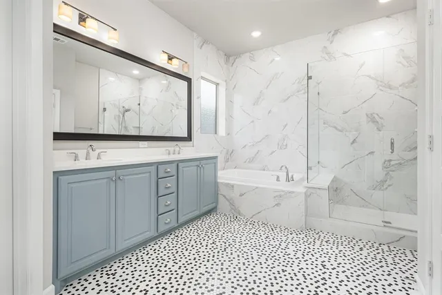 a bathroom with a bathtub sink vanity and mirror