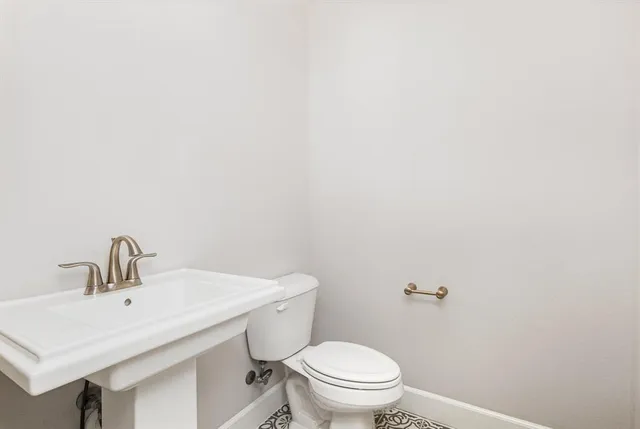 a bathroom with a toilet a sink and mirror