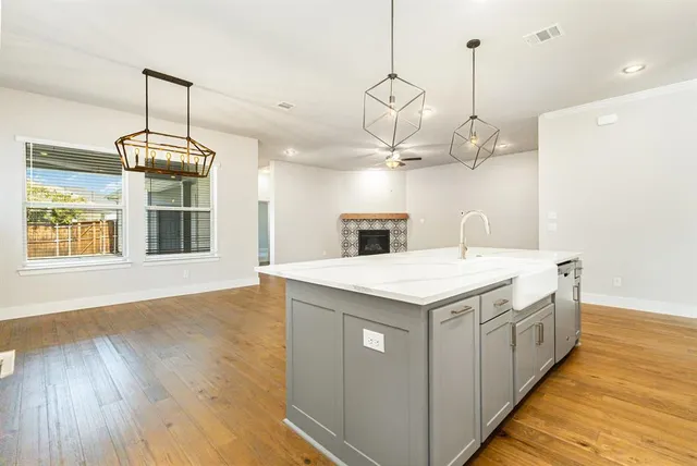 a kitchen that has a lot of cabinets and wooden floor
