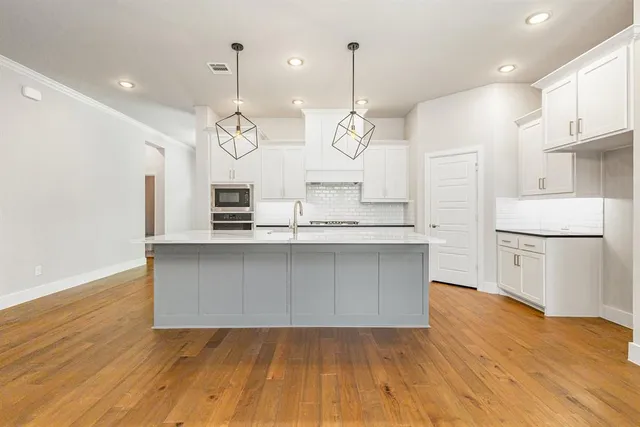 a kitchen with kitchen island a sink and a stove