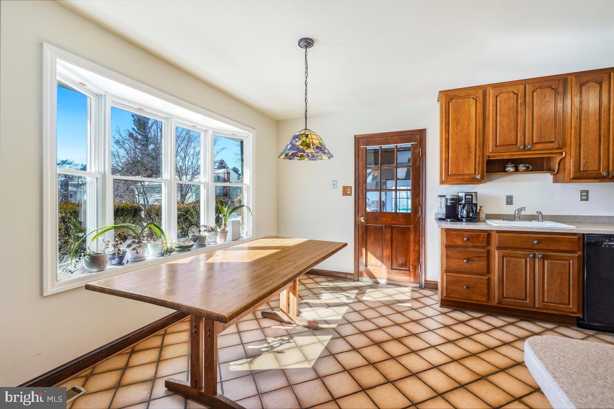 24357 Flamingo Terrace Gaithersburg, MD 20882 - Photo 11 of 41 a open kitchen with stainless steel appliances granite countertop a stove a refrigerator a sink dishwasher with a dining table and chair with wooden floor