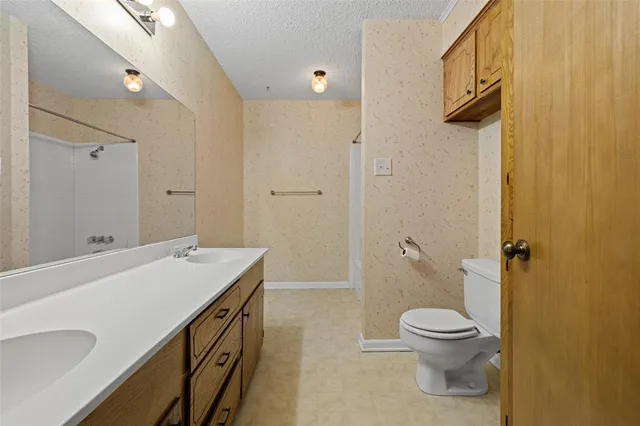 a view of a hallway with wooden floor and a bathroom
