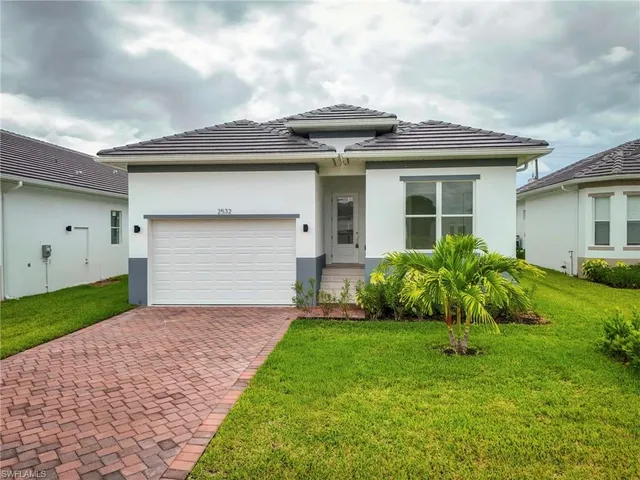 a front view of a house with a garden and plants