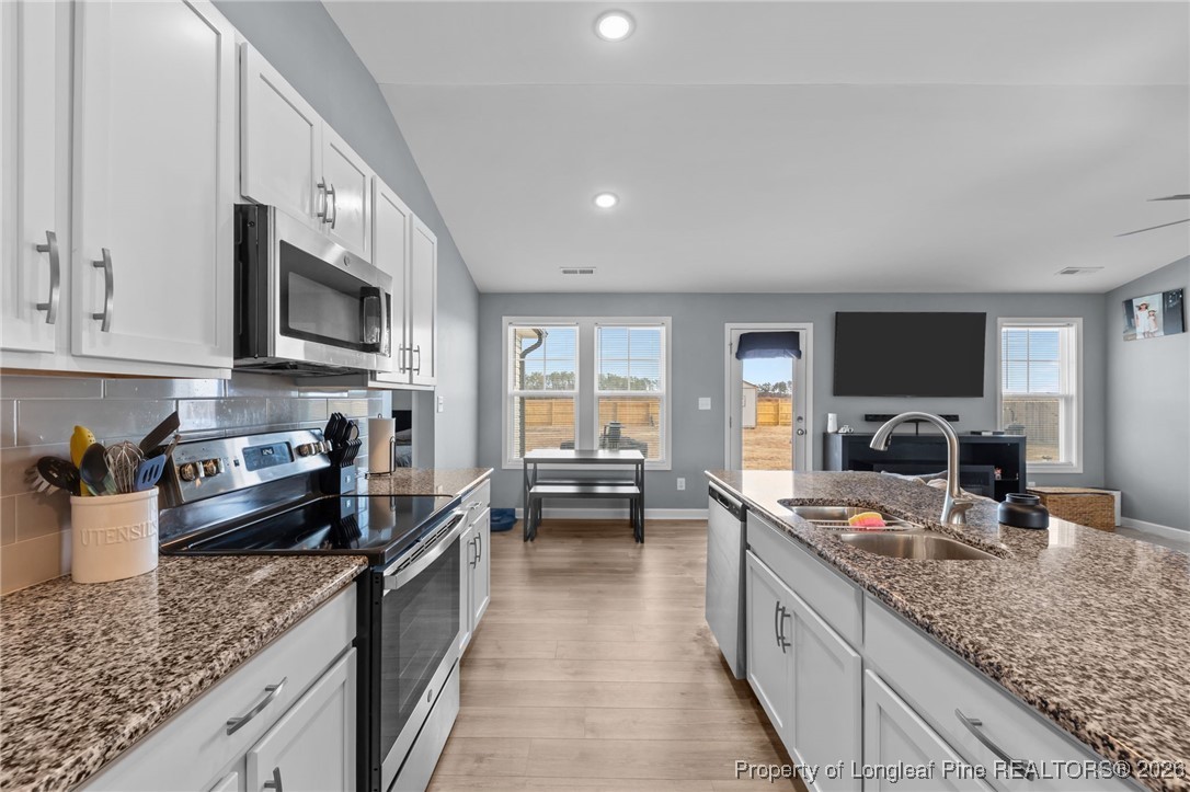 522 Carolina Church Road St. Pauls, NC 28384 - Photo 11 of 36 a kitchen with stainless steel appliances granite countertop a sink stove and refrigerator