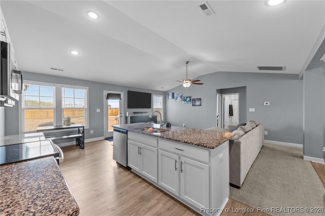 522 Carolina Church Road St. Pauls, NC 28384 - Photo 12 of 36 a spacious bathroom with a granite countertop sink a mirror a bathtub and next to a window
