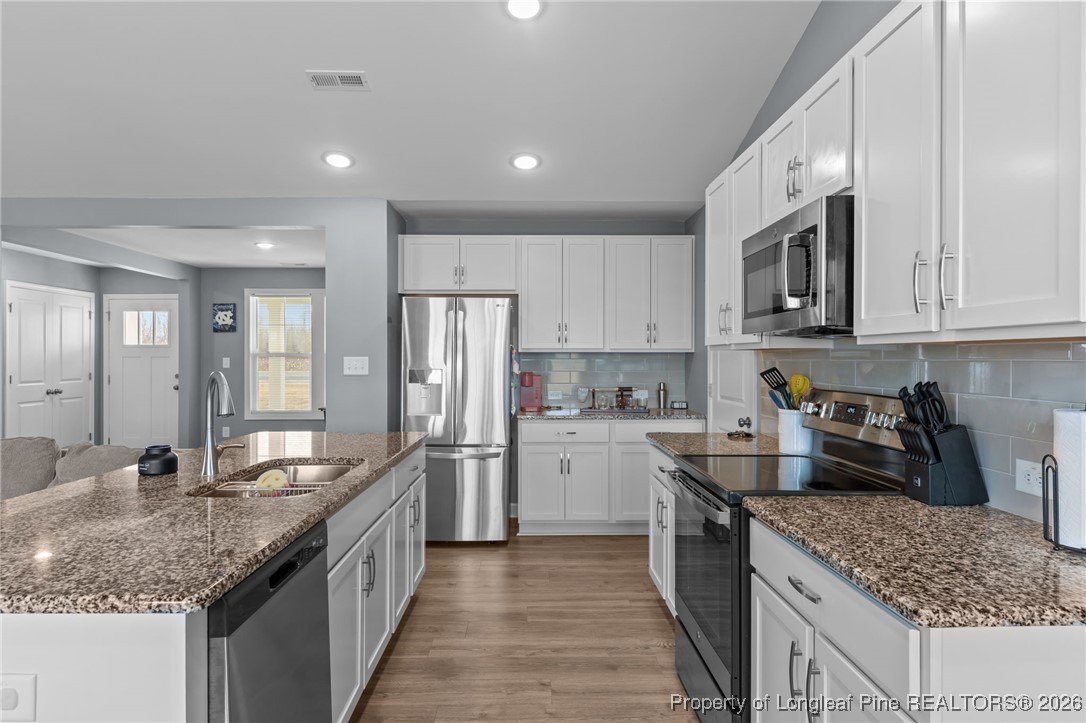 522 Carolina Church Road St. Pauls, NC 28384 - Photo 9 of 36 a kitchen with stainless steel appliances granite countertop a sink stove and refrigerator