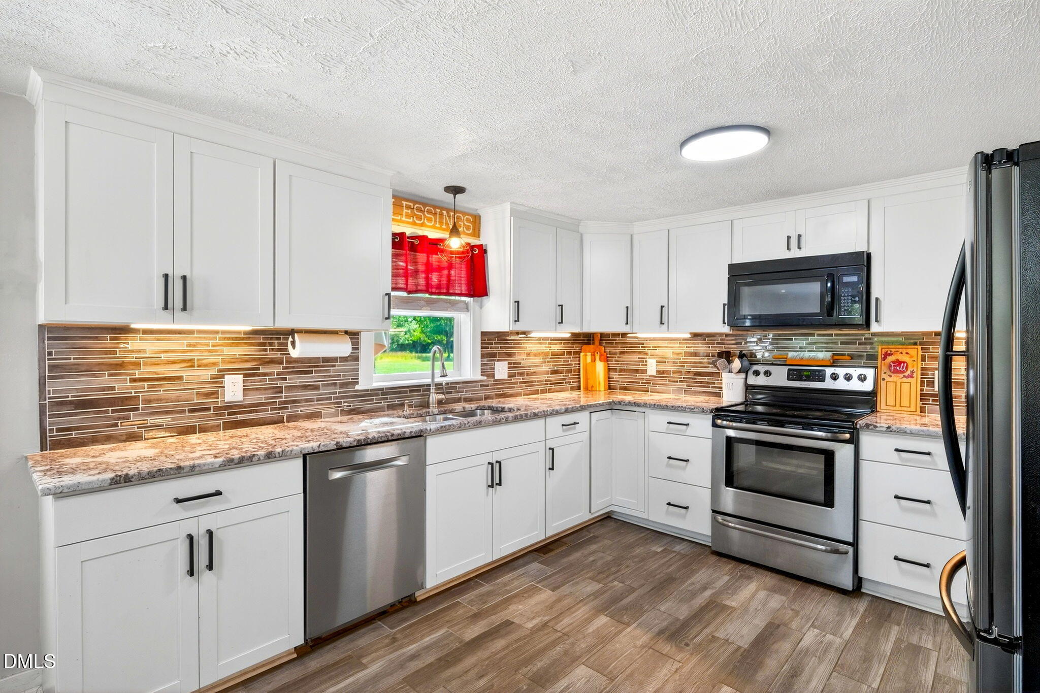 334 Perry Curtis Road Zebulon, NC 27597 - Photo 14 of 38 a kitchen with granite countertop a stove top oven and sink