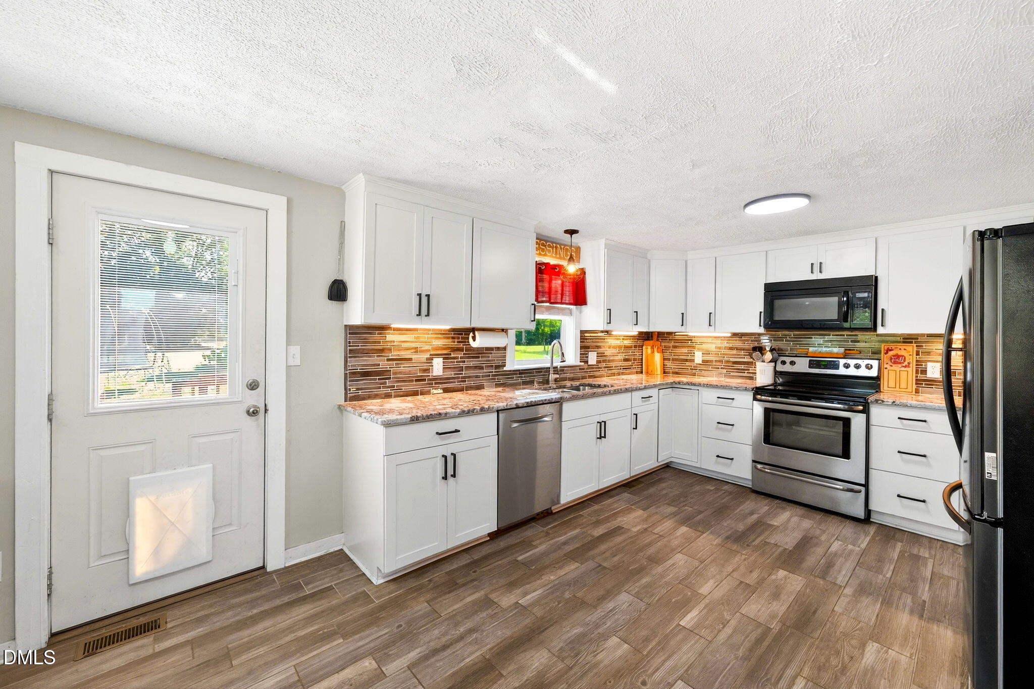 334 Perry Curtis Road Zebulon, NC 27597 - Photo 17 of 38 a kitchen with granite countertop stainless steel appliances and wooden cabinets